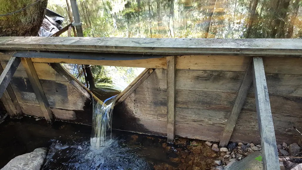 Bilden visar en dammanläggning för mätning av vattenflöde i en skogsbäck i Asa.