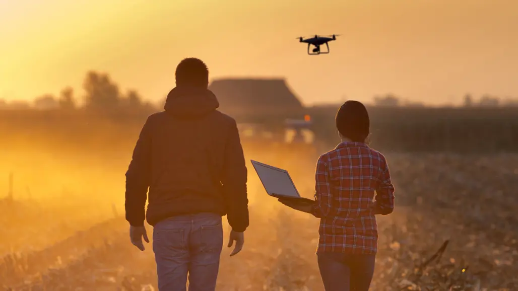 Two people on an agricultural field with a drone. Photo.