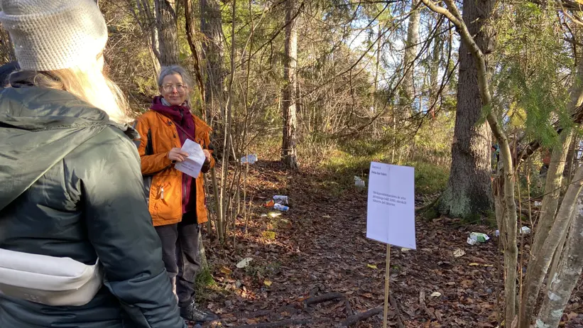 Två personer i en skog på hösten. Skräp på marken.