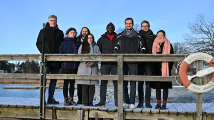 Eight people standing on a bridge.