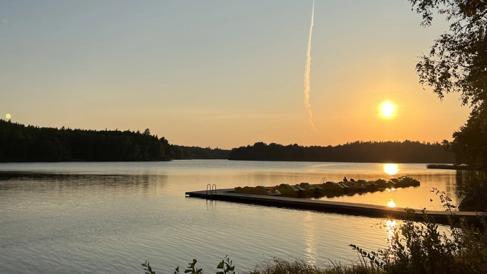 solnedgång över sjö. Foto.