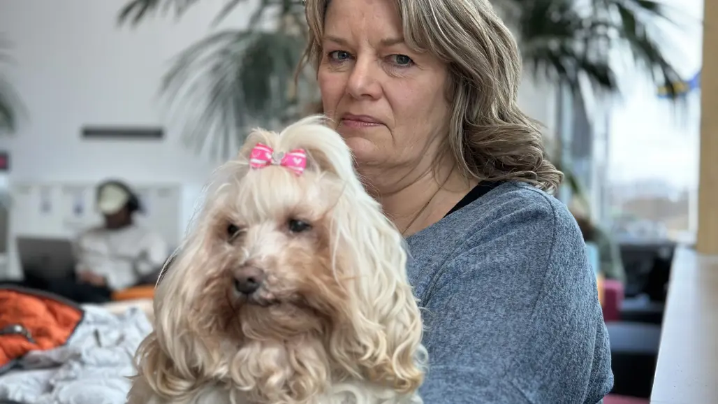 En kvinna sitter med sin hund i knäet