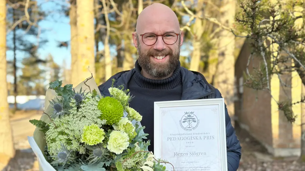 Man med diplom och blombukett
