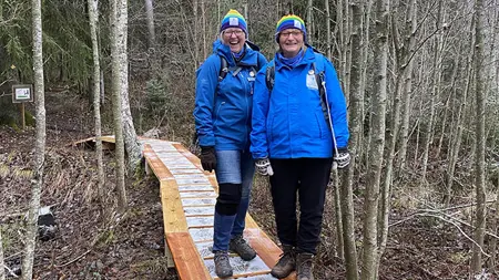 Mulleledarna Ewa Palm och Elisabeth Tugén står på spången som leder in i skogen.