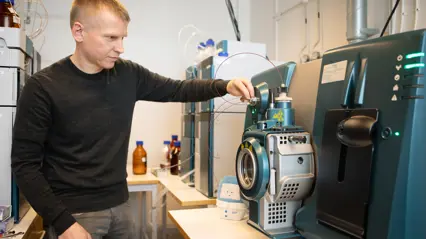 En man justerar avancerad laboratorieutrustning i ett kemilabb.