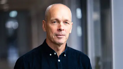 En person i mörk skjorta och ljust kort hår